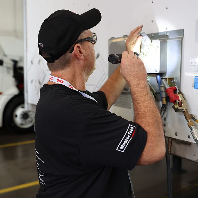 An XPO mechanic working on a truck