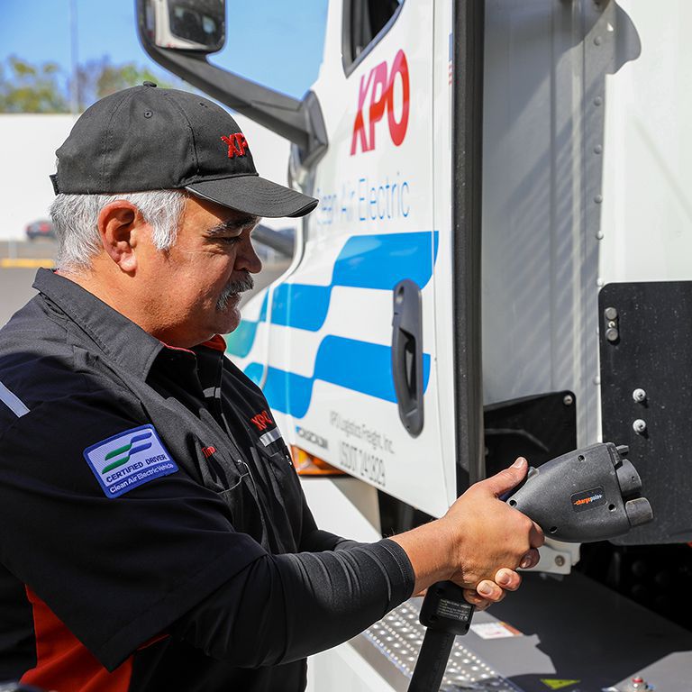 An XPO mechanic charging a frieght truck
