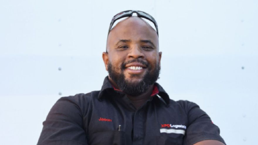 A culture of winning An XPO employee with glasses on his head is smiling