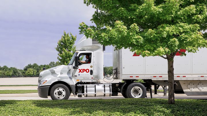 How XPO Supports Military Members XPO wrapped military truck behind a tree